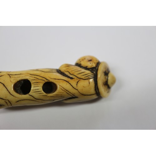 117 - A Japanese carved antler netsuke, formed as a Dutchman holding a ham hock, 2 1/4