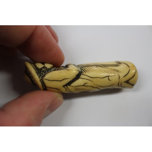 117 - A Japanese carved antler netsuke, formed as a Dutchman holding a ham hock, 2 1/4