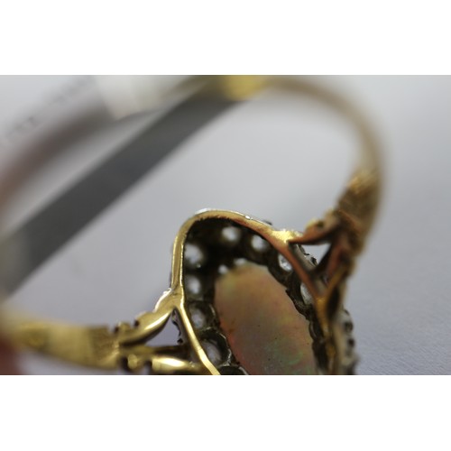 337 - An 18ct yellow gold dress ring, set oval opal with collar of diamonds, opal 13mm x 6mm approx, size ... 