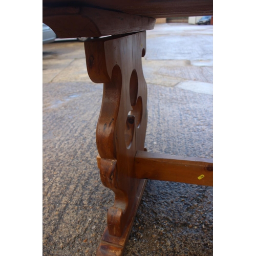 742 - A pine plank top refectory type table, on pierced panel end supports, top 66