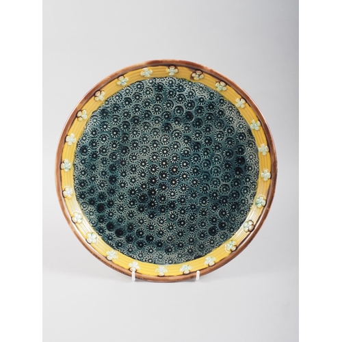 10 - A Wedgwood circular tray with blue glazed centre decorated flower heads, 10 1/2