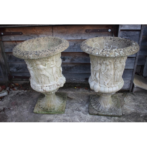 753 - A pair of cast stone urns with classical decoration, on square bases, 42