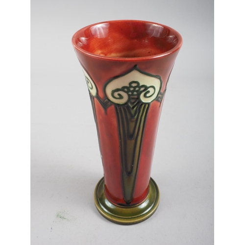 8 - A Mintons Secessionist design slender tapering vase, decorated in red and green, 7 1/2