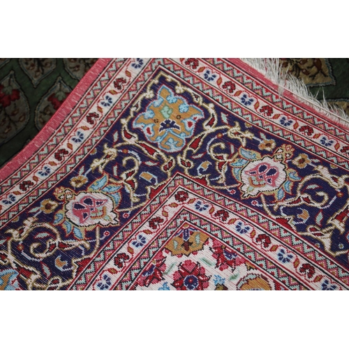 745 - A Qum silk rug with floral elephant guls, central medallion and triple guarded blue borders on a gre... 