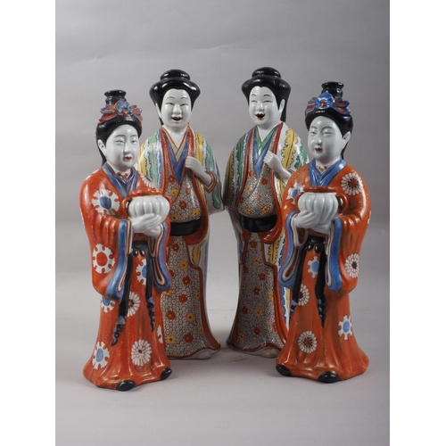 89 - A pair of Chinese porcelain figures of women in orange robes holding jars, 14