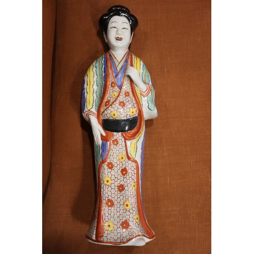 89 - A pair of Chinese porcelain figures of women in orange robes holding jars, 14