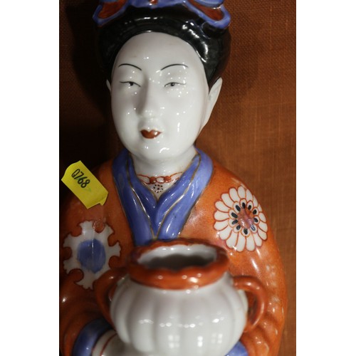 89 - A pair of Chinese porcelain figures of women in orange robes holding jars, 14