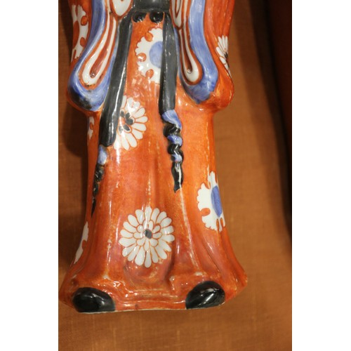 89 - A pair of Chinese porcelain figures of women in orange robes holding jars, 14