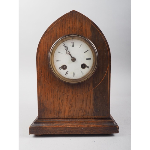 124 - An early 20th century oak arch top mantel clock with line inlay and eight-day striking movement with... 