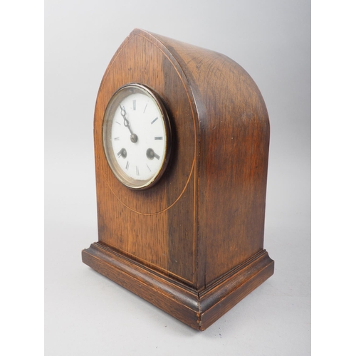 124 - An early 20th century oak arch top mantel clock with line inlay and eight-day striking movement with... 