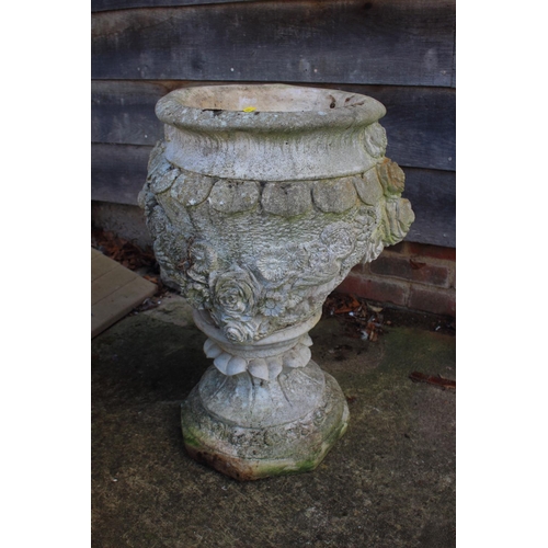 550 - A cast stone urn with relief decoration of roses, 26