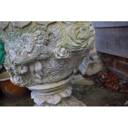 550 - A cast stone urn with relief decoration of roses, 26