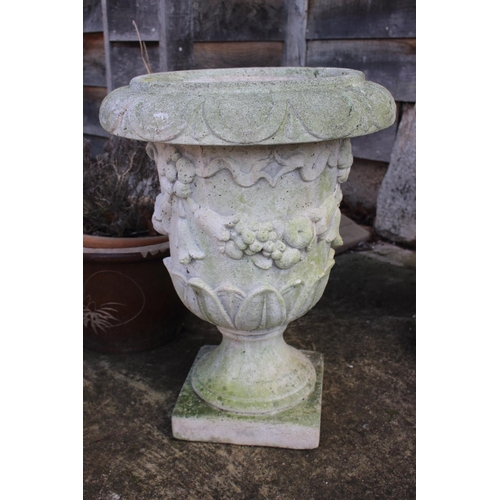 551 - A cast stone urn with swag decoration, 22