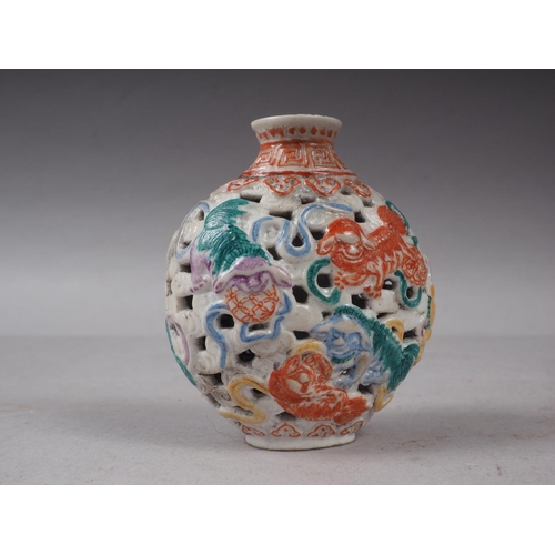 86 - A Chinese porcelain pierced and relief decorated snuff bottle, no stopper, seal mark to base, 2 5/8