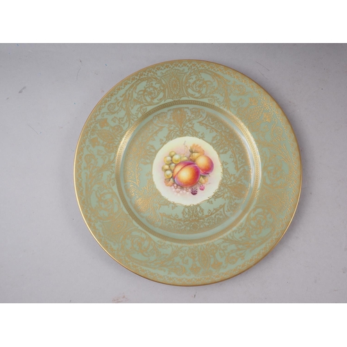 9 - A pair of Royal Worcester cabinet plates with celadon glazed and gilt borders and central fruit deco... 