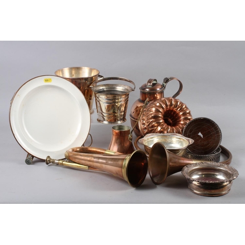 144 - An assortment of metalware, including a pair of silver plated wine bottle coasters, a copper jersey ... 