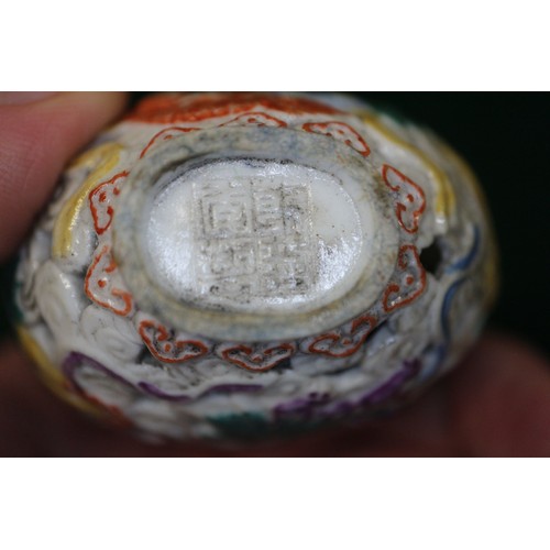 86 - A Chinese porcelain pierced and relief decorated snuff bottle, no stopper, seal mark to base, 2 5/8