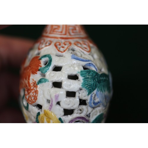 86 - A Chinese porcelain pierced and relief decorated snuff bottle, no stopper, seal mark to base, 2 5/8