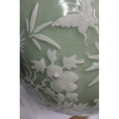 100 - A Chinese porcelain celadon glazed bowl, decorated in high relief with flowers and butterflies, 10 1... 