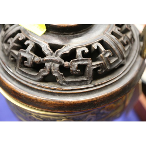 107 - A Chinese brass censor with engraved decorated and carved wooden top and amethyst knop, on three tap... 