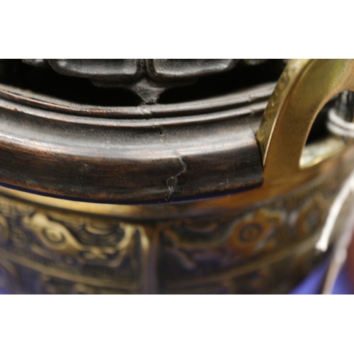 107 - A Chinese brass censor with engraved decorated and carved wooden top and amethyst knop, on three tap... 