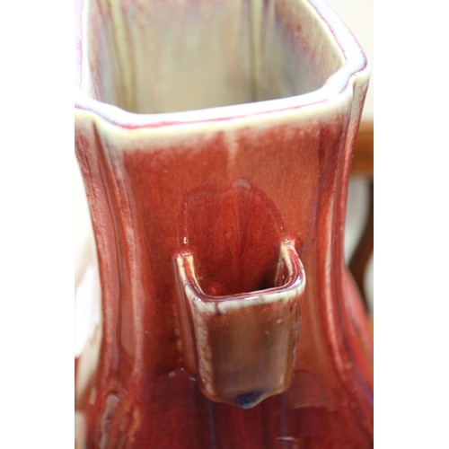 80 - A sang de beouf glazed bulbous vase with handles, 11 3/4