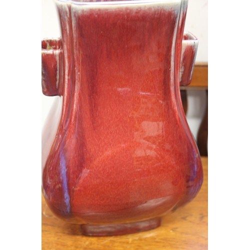 80 - A sang de beouf glazed bulbous vase with handles, 11 3/4