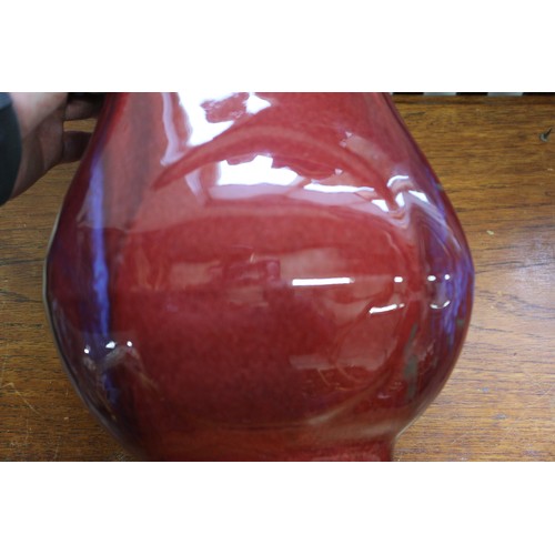 80 - A sang de beouf glazed bulbous vase with handles, 11 3/4