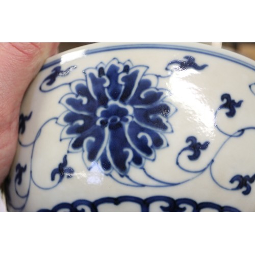 70 - A Chinese blue and white bowl with lotus flower and scrolled decoration, six character mark to base,... 