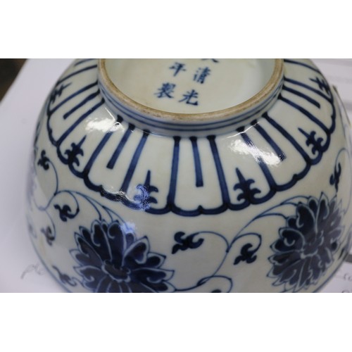 70 - A Chinese blue and white bowl with lotus flower and scrolled decoration, six character mark to base,... 