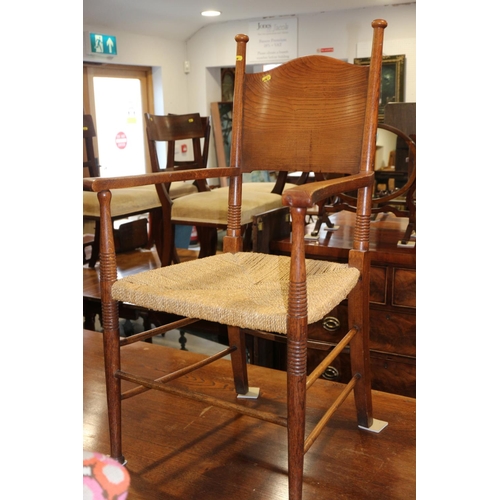 415 - A William Birch oak panel back elbow chair with string envelope seat, on turned and stretchered supp... 