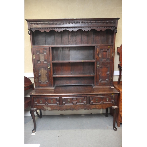 437 - A 19th century oak dresser, the upper section fitted open shelves and cupboards enclosed panelled do... 