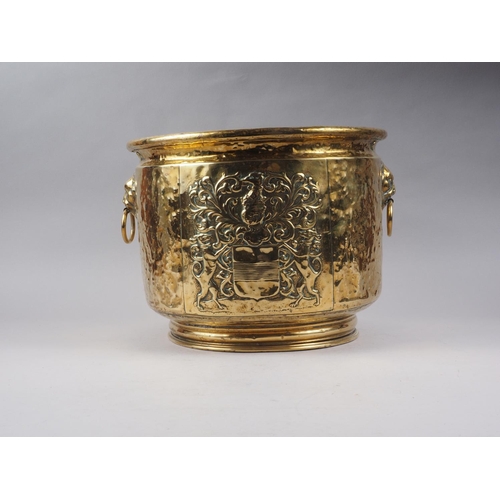 139 - A hammered and embossed brass coal scuttle with coat of arms decoration, 14