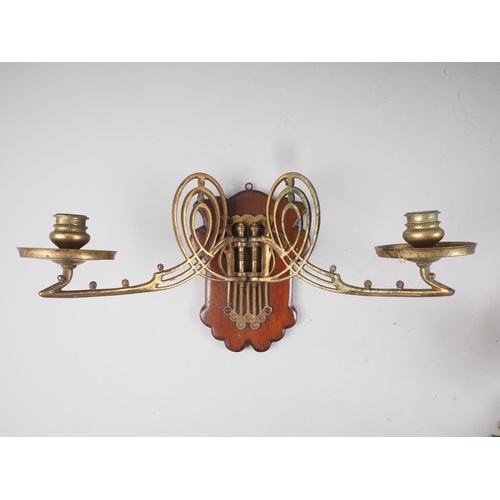 198 - A pair of Art Deco brass two-branch wall sconces with walnut back plates, a pair of two-branch griff... 