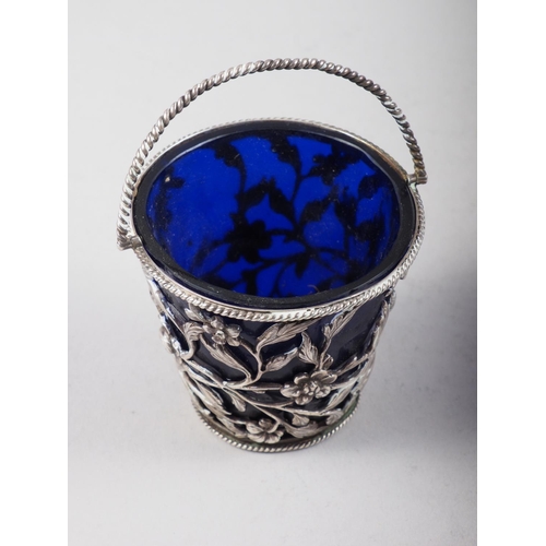 264 - A Georgian silver swing-handled sugar basket with floral decoration and blue glass liner