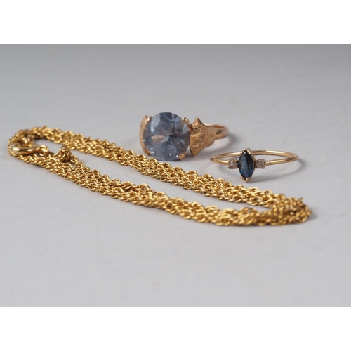 307 - An Egyptian yellow metal ring set topaz, a yellow metal three-stone ring and a chain