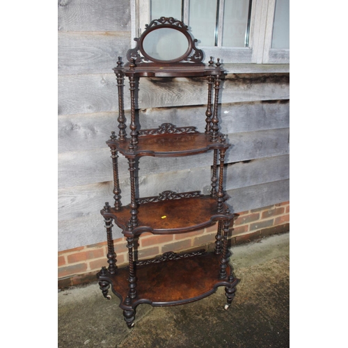 419 - A late 19th century figured walnut four-tier shape front whatnot with oval mirror over spiral turned... 