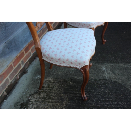 423 - A pair of Victorian carved walnut loop back side chairs, on cabriole supports