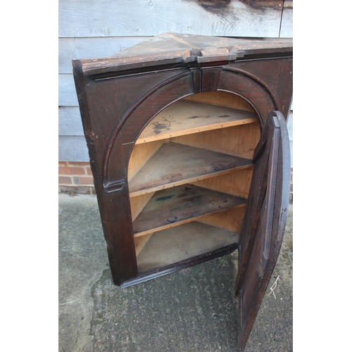 434 - An 18th century oak corner hanging cupboard, fitted shaped shelves enclosed arch top panel door, 33