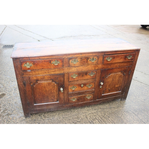 439 - A Georgian oak dresser base, fitted three drawers over three small drawers with flanking cupboards e... 