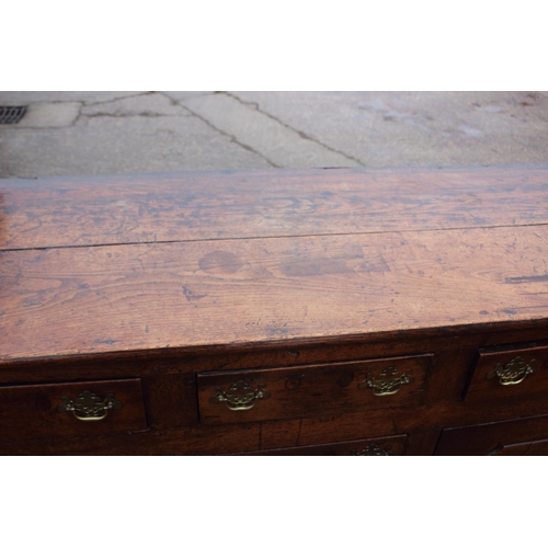 439 - A Georgian oak dresser base, fitted three drawers over three small drawers with flanking cupboards e... 