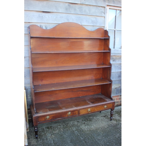 448 - An early 19th century mahogany shaped back waterfall bookcase, fitted two drawers, on turned and tap... 