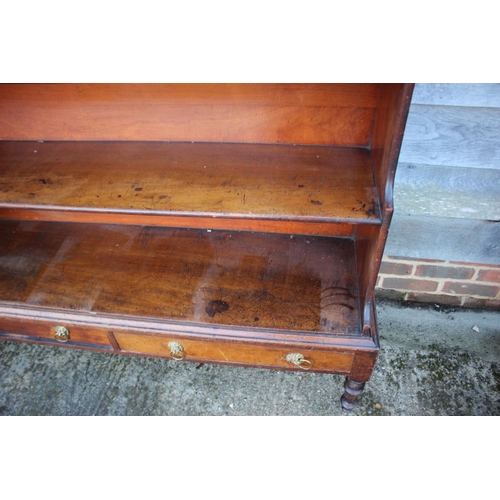 448 - An early 19th century mahogany shaped back waterfall bookcase, fitted two drawers, on turned and tap... 