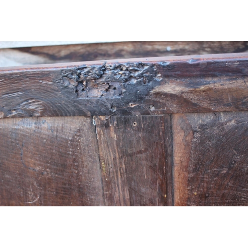 457 - An early 18th century oak four panel front coffer with hinged lid, on stile supports, 53