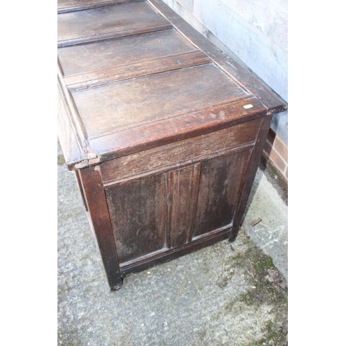 457 - An early 18th century oak four panel front coffer with hinged lid, on stile supports, 53