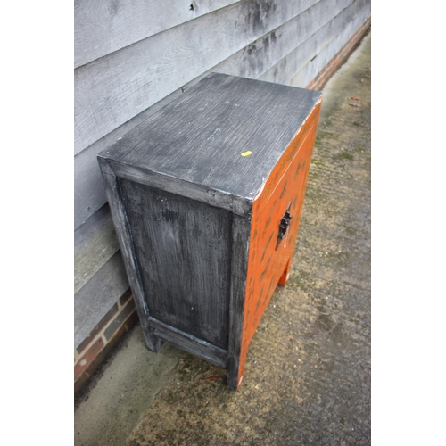 466 - A Chinese red lacquered butterfly decorated cupboard, on stile supports, 22