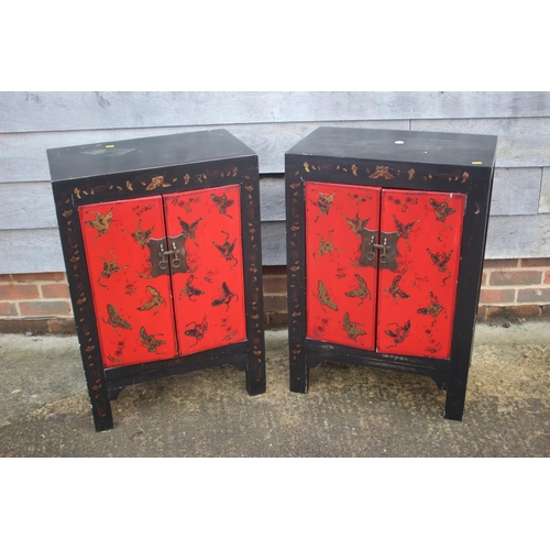 467 - A pair of red lacquered and black butterfly decorated side cupboards, 22 1/2