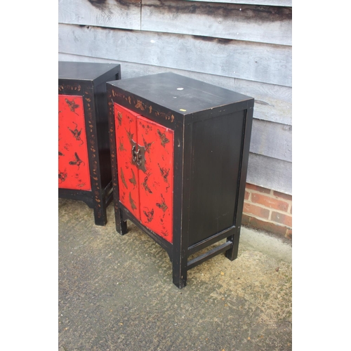 467 - A pair of red lacquered and black butterfly decorated side cupboards, 22 1/2