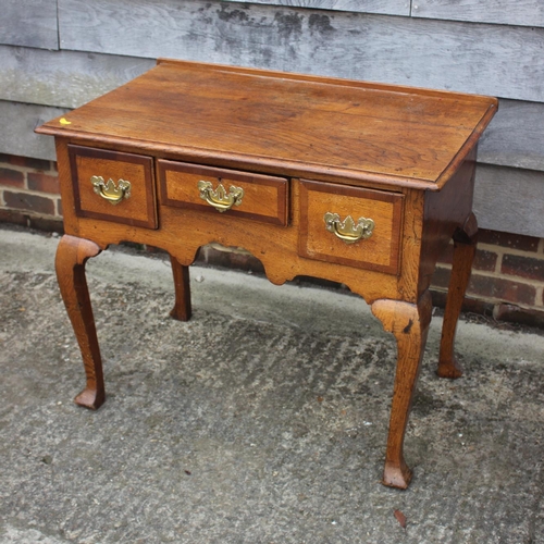 474 - A Georgian provincial oak and mahogany banded lowboy, fitted one shallow and two deep drawers, on ca... 