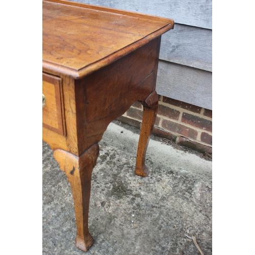 474 - A Georgian provincial oak and mahogany banded lowboy, fitted one shallow and two deep drawers, on ca... 